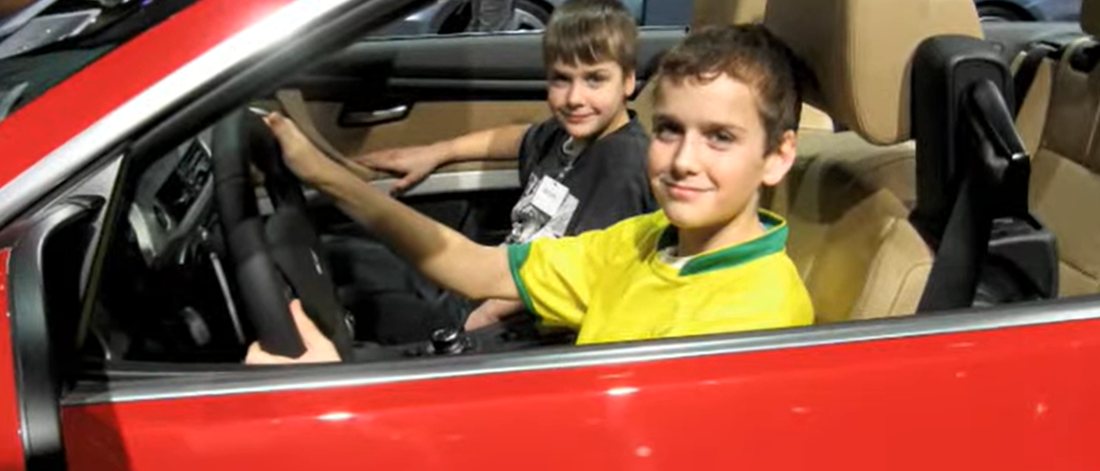 Two brothers in a red convertible at the 2010 Detroit auto show