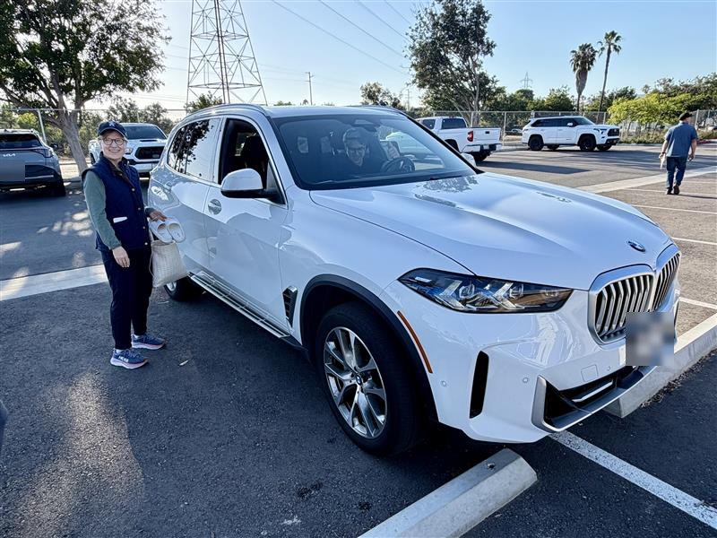 White BMW X5 in a San Diego parking lot with my mom standing beside it